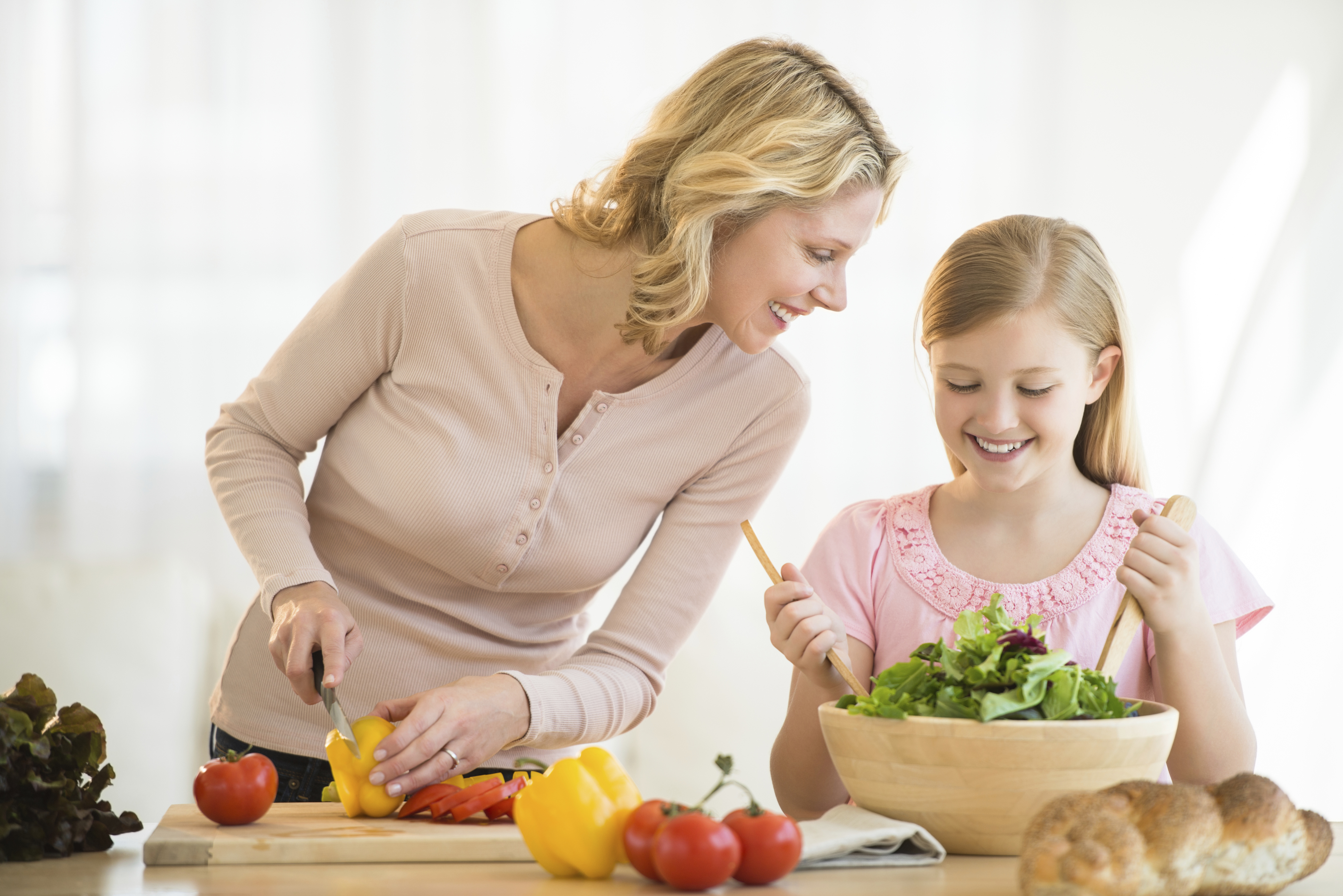 Girl Assisting Mother In Preparing Food At Counter